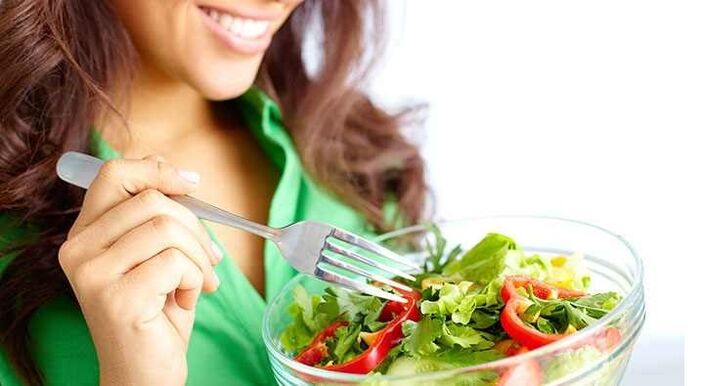 Meedchen iessen Geméis Salat op enger Protein Diät